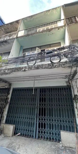 店屋 出租在Watthana, Bangkok - 瓦他那区临街多层店屋外观，带阳台与旧式立面，门前有电缆，靠近帕卡农BTS。