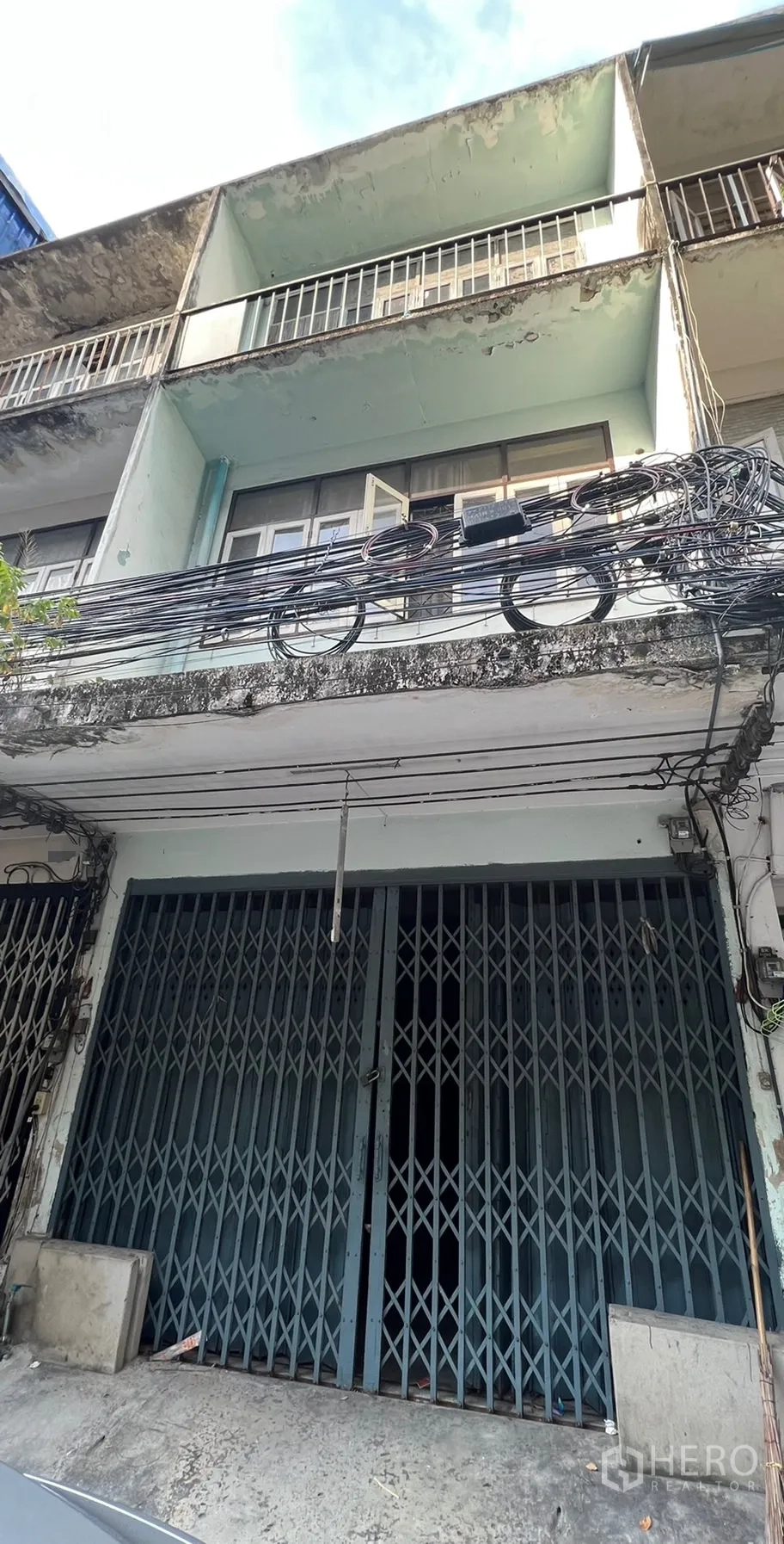 店屋 出租在Watthana, Bangkok - 瓦他那区临街多层店屋外观，带阳台与旧式立面，门前有电缆，靠近帕卡农BTS。