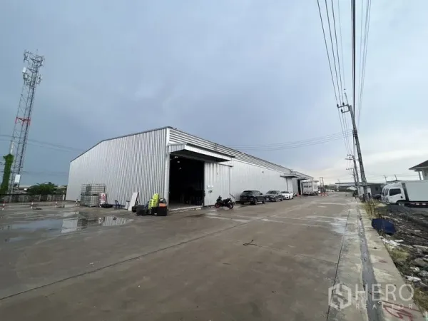คลังสินค้า ให้เช่าในLat Krabang, Bangkok - ภายนอกโกดังผนังเมทัลชีทขนาดใหญ่ ประตูโหลดสินค้าเปิดกว้าง พร้อมลานคอนกรีตกว้างรองรับรถคอนเทนเนอร์
