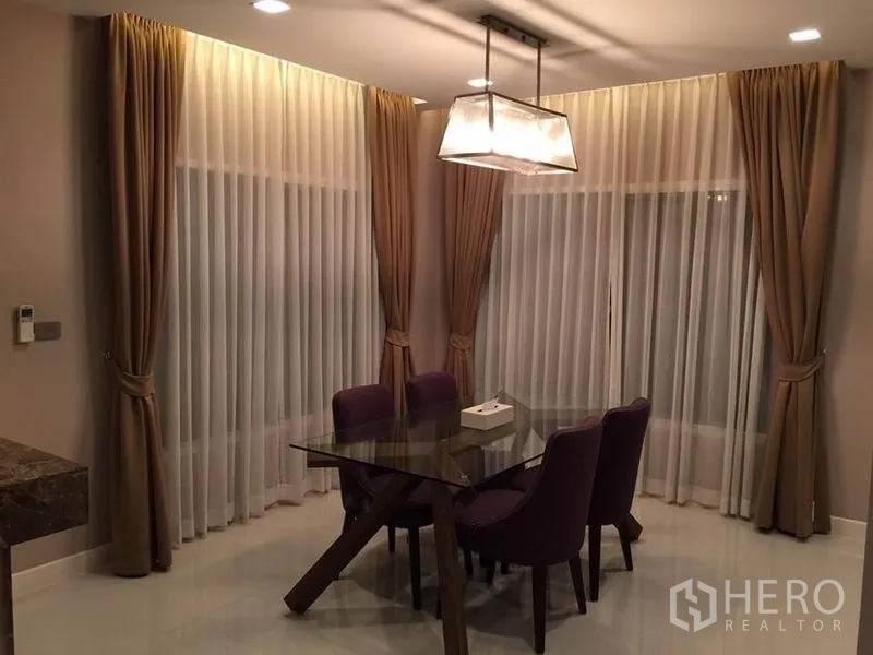 บ้าน ให้เช่าหรือขายในKhlong Toei, Bangkok - มุมรับประทานอาหารสวยงาม โต๊ะกระจก เก้าอี้สีม่วง ผ้าม่านทึบและโปร่ง พร้อมโคมไฟห้อย