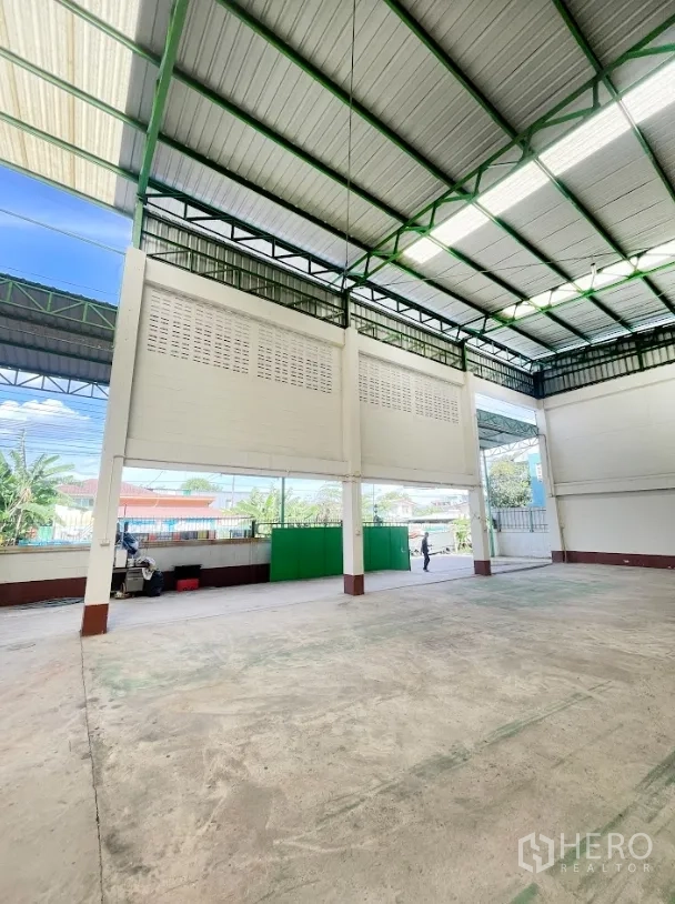 Warehouse for rent or sale in Thanyaburi, Pathum Thani - High-bay loading zone with tall entrance gate and open-air ventilation walls.