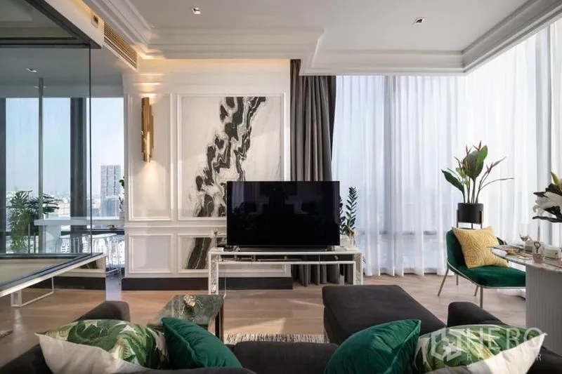 Condominium for rent in Bang Rak, Bangkok - Living area with marble feature wall, large TV and greenery beside wraparound windows.