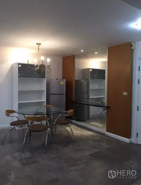 คอนโด ให้เช่าหรือขายในWatthana, Bangkok - โซนรับประทานอาหารพร้อมโต๊ะกระจก โคมไฟแชนเดอเลียร์ ชั้นวางของ และผนังกระจกข้างตู้เย็นสแตนเลส