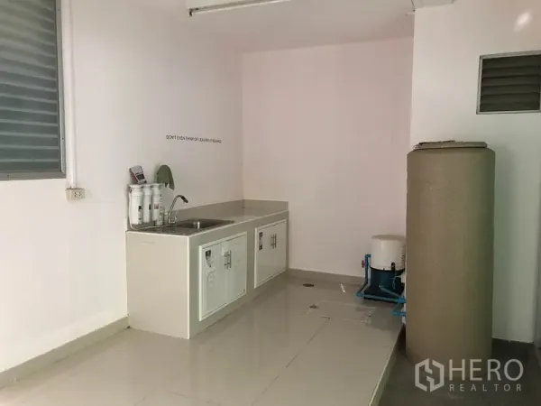 ทาวน์เฮาส์ ให้เช่าในSuan Luang, Bangkok - ครัวไทยขนาดกะทัดรัด มีอ่างล้างมือ ตู้เก็บของ และระบบกรองน้ำข้างถังเก็บน้ำ