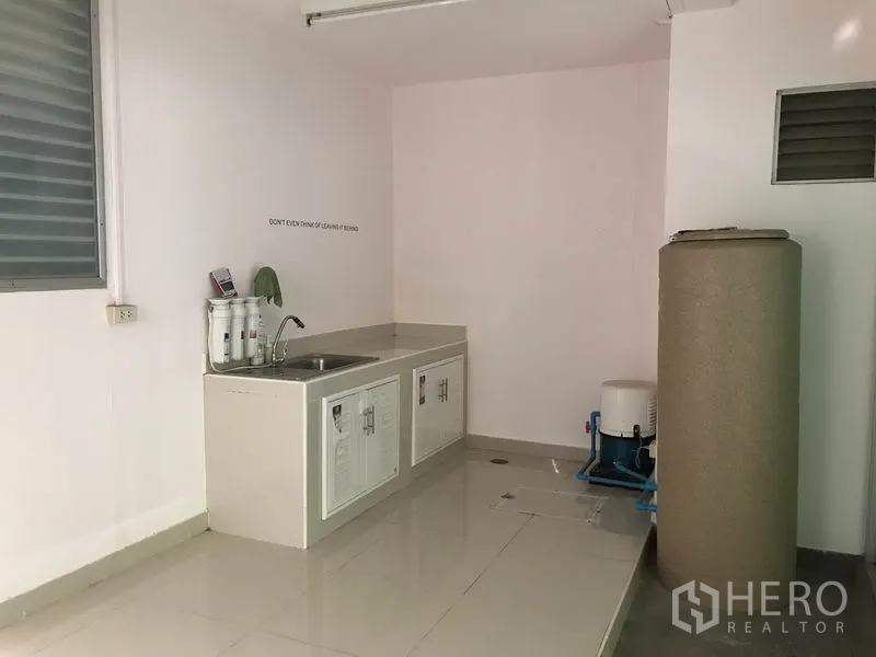 ทาวน์เฮาส์ ให้เช่าในSuan Luang, Bangkok - ครัวไทยขนาดกะทัดรัด มีอ่างล้างมือ ตู้เก็บของ และระบบกรองน้ำข้างถังเก็บน้ำ