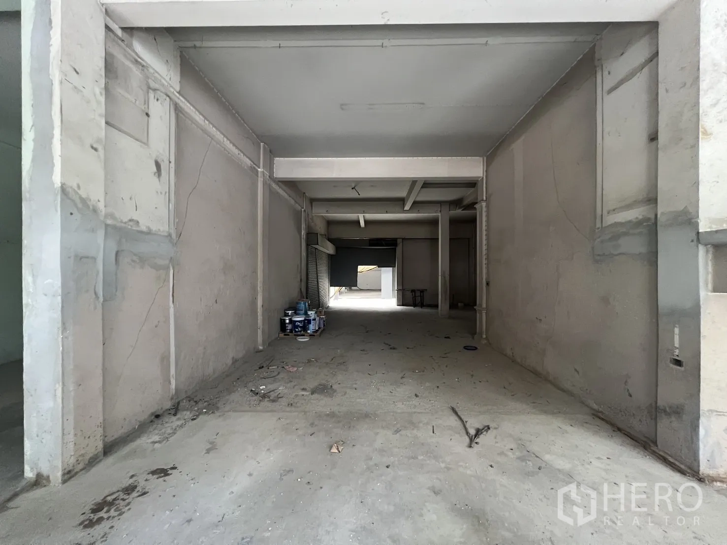 店屋 for rent in Bang Rak, Bangkok - 狭长大厅，水泥地面和成堆油漆桶。