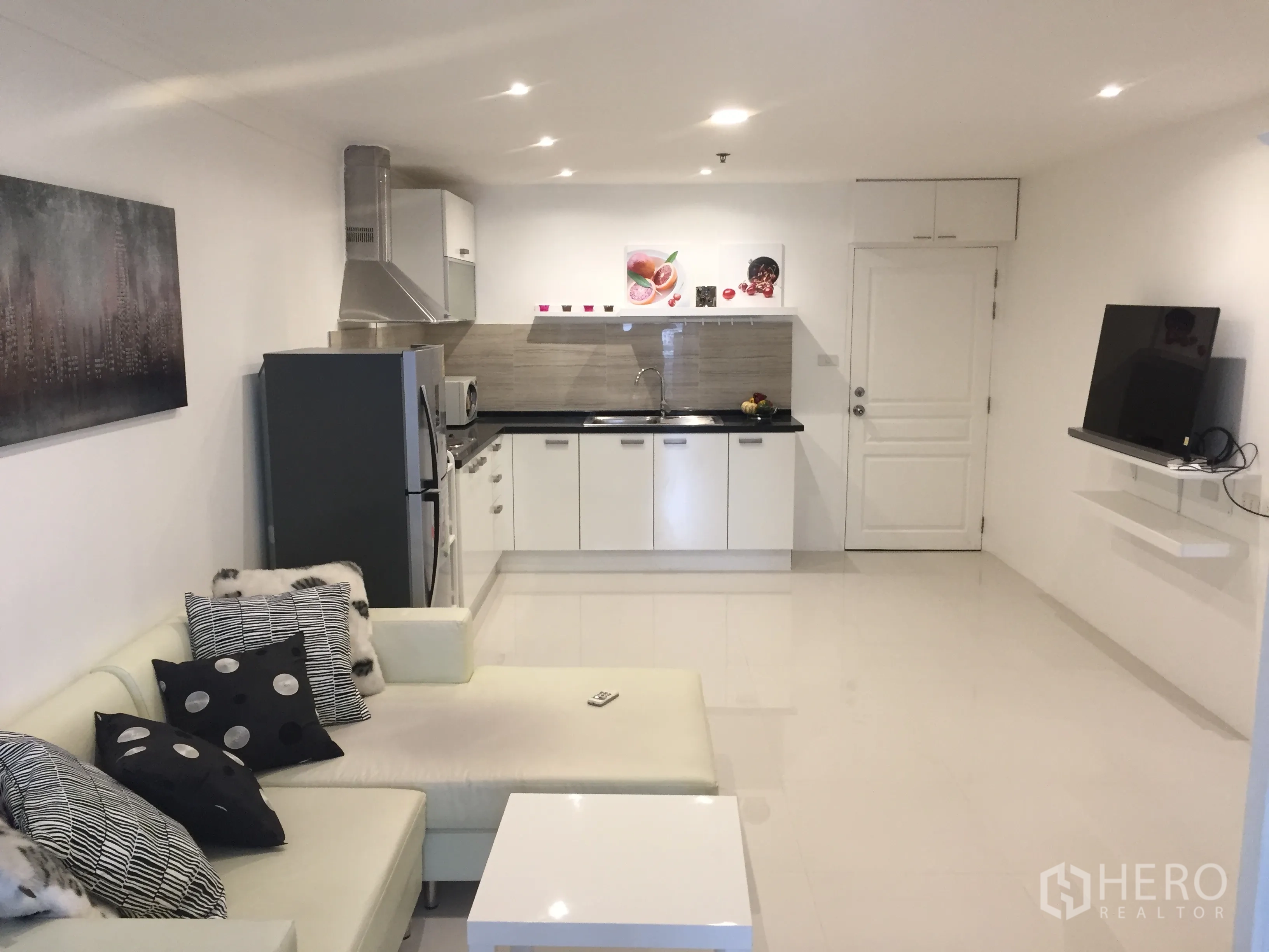 คอนโด ขายในKhlong Toei, Bangkok - พื้นที่นั่งเล่นแบบโอเพ่นคอนเซ็ปต์ ครัวสีขาว เครื่องดูดควัน ตู้เย็น ทีวีติดผนัง และโซฟา