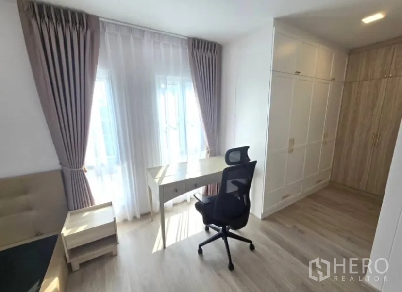 Detached House for rent in Bang Phli, Samut Prakan - Bedroom with built‑in wardrobes, full curtains and a writing desk by the window.