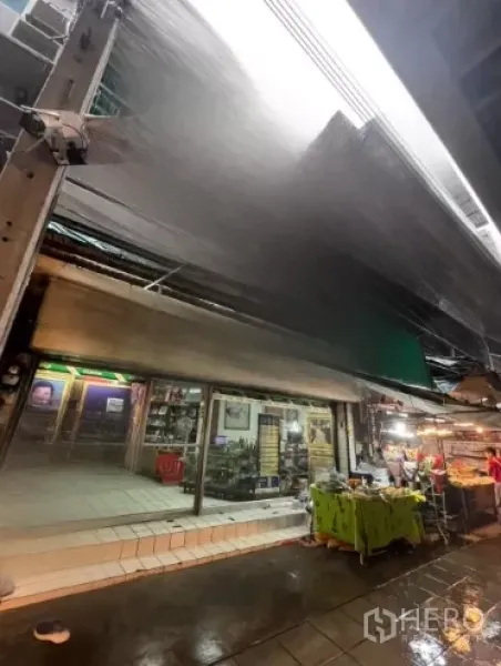 店屋 出租在Watthana, Bangkok - 带金属雨棚的商铺立面，临近湿滑的市场通道