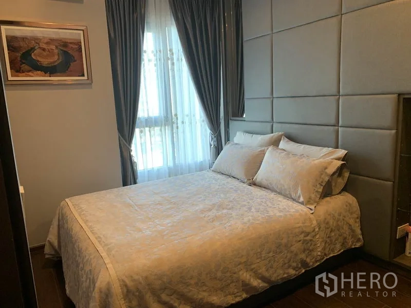 公寓 出售在Watthana, Bangkok - 软包床头的卧室，双人床临窗摆放，配有窗帘。