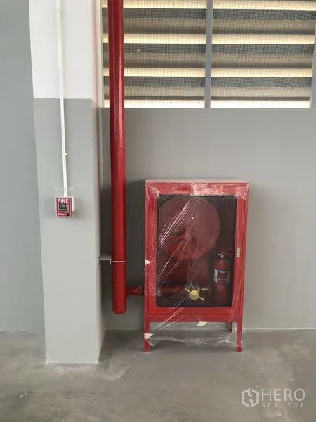 工厂 出租或出售在Samut Prakan - 墙面安装的红色消防水带箱与喷淋管道。