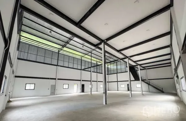 คลังสินค้า ให้เช่าในBang Phli, Samut Prakan - ฮอลล์โกดังโปร่งสูง มีแผงรับแสงสกายไลต์ เสาเหล็ก และบันไดด้านข้าง