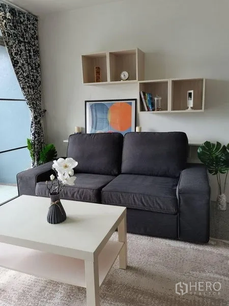 公寓 出租在Khlong Toei, Bangkok - 客厅配灰色沙发、白色茶几、壁柜与窗帘。