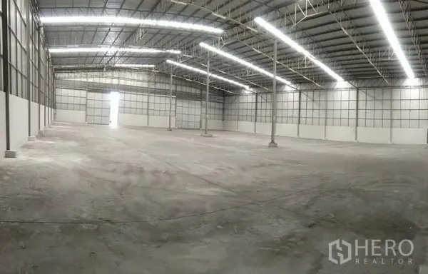 คลังสินค้า ให้เช่าในBang Phli, Samut Prakan - ภาพมุมกว้างภายในโกดัง เสากลางหลายต้น ช่องแสง และประตูม้วนอุตสาหกรรม
