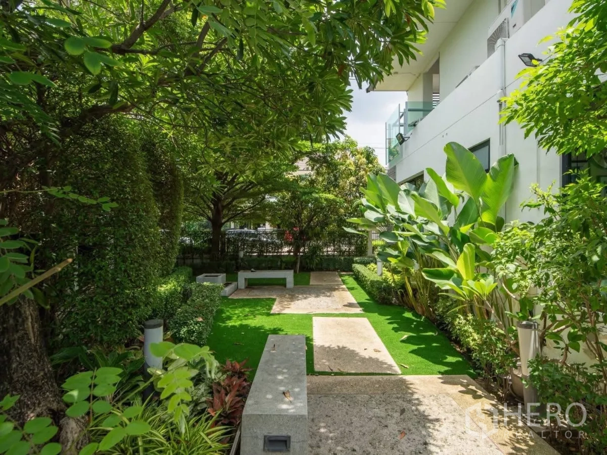 Detached House for rent or sale in Prawet, Bangkok - Shaded garden with manicured lawn, mature trees and seating benches.