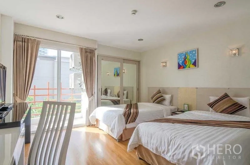 คอนโด ให้เช่าในKhlong Toei, Bangkok - ห้องนอนแขกเตียงเดี่ยวคู่ โต๊ะทำงาน ตู้เสื้อผ้าบานกระจก และประตูออกระเบียง