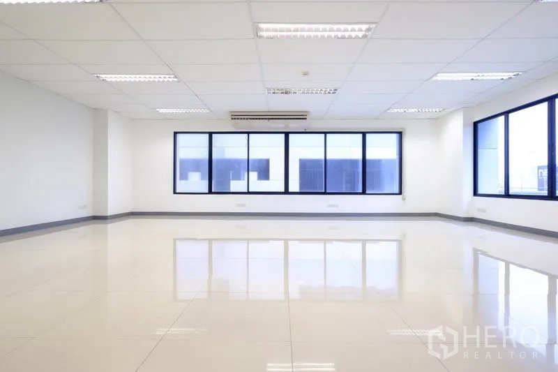 Office Space for rent in Suan Luang, Bangkok - Modern restroom with toilet, sink, urinal and large illuminated mirror.