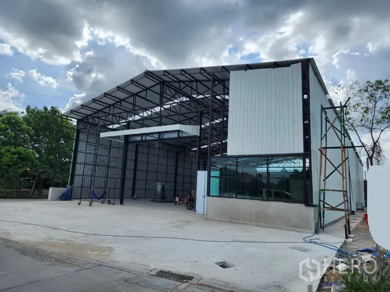 Warehouse for rent in Pak Kret, Nonthaburi - Warehouse frontage with high entry canopy, glass corner office and spacious loading apron.