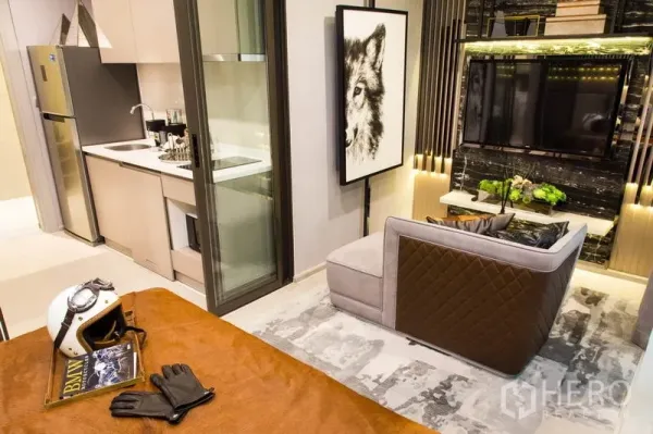 公寓 出售在Ratchathewi, Bangkok - 开放式一居布局，可见床、厨房、推拉玻璃门、沙发与电视墙。