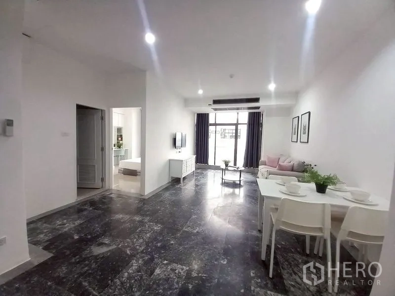 Condominium for rent in Watthana, Bangkok - Bright lounge facing the balcony with dining nook and wall TV.