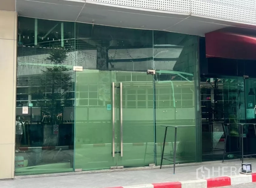 零售空间 出租 - 近BTS帕卡农的零售铺面特写，双扇玻璃门与整面玻璃立面。