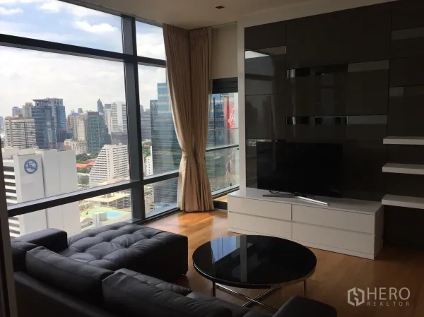 Condominium for rent in Ratchathewi, Bangkok - Living room with floor-to-ceiling windows and wide Bangkok skyline view in a Ratchathewi condo.