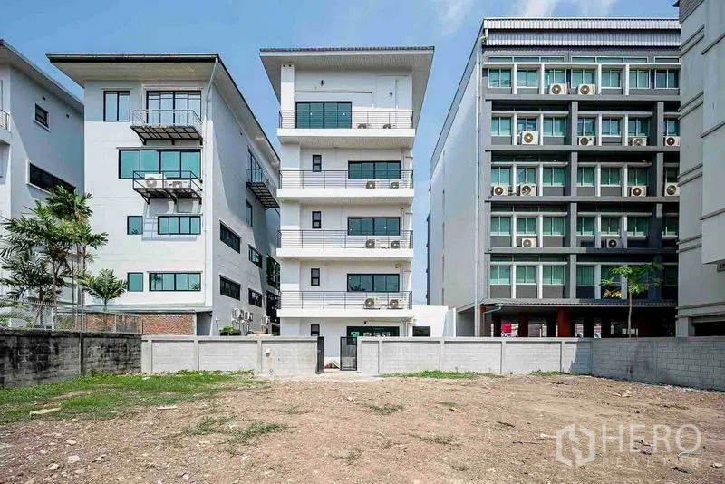 Home Office for rent in Suan Luang, Bangkok - Rear elevation of the multi-storey building flanked by neighboring offices, looking over the walled yard.