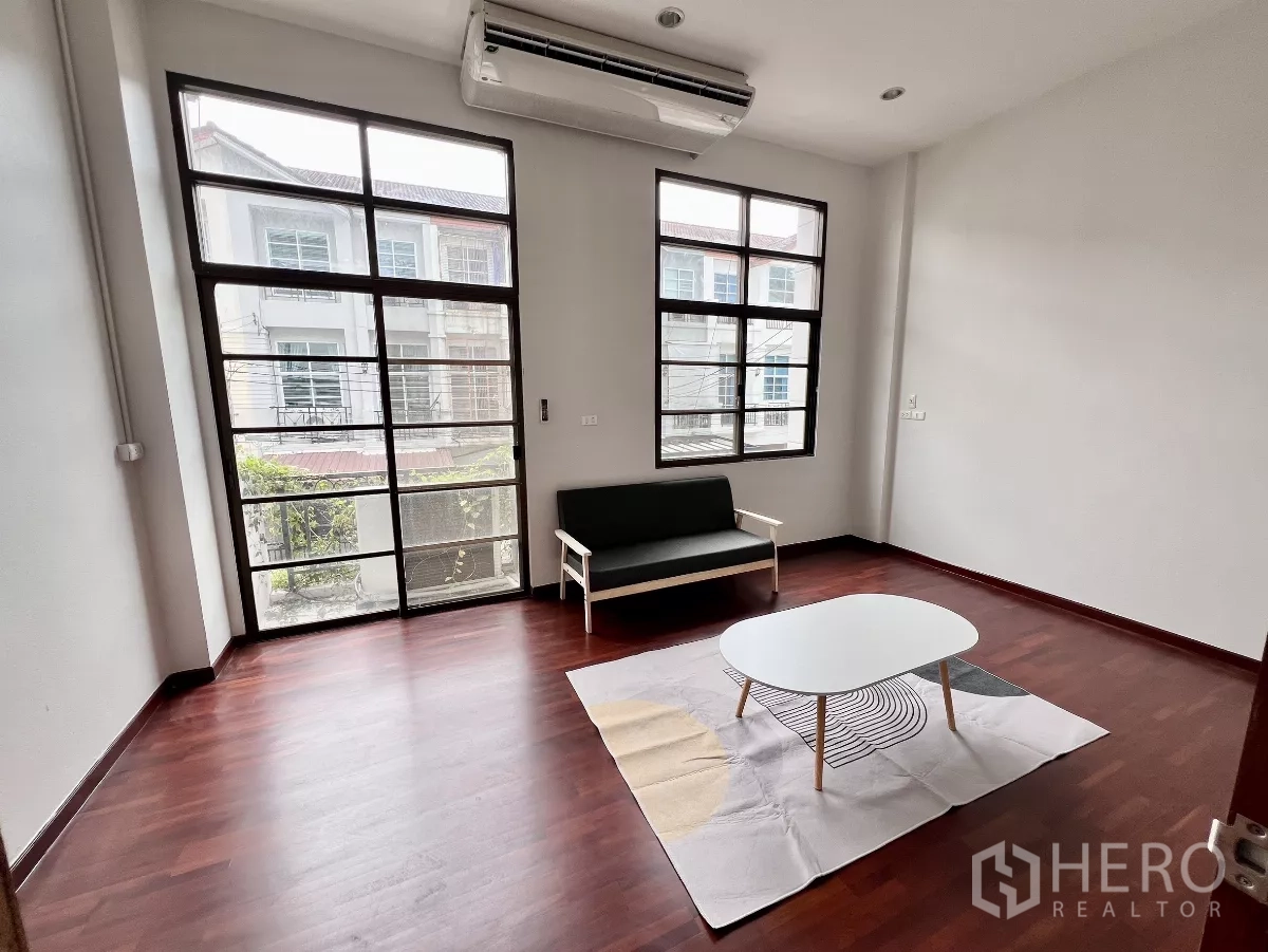 ทาวน์เฮาส์ ให้เช่าหรือขายในPhra Khanong, Bangkok - ห้องนั่งเล่นพื้นไม้ หน้าต่างสูงจรดเพดาน โซฟาและโต๊ะกลาง