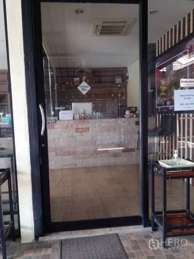 Shophouse for sale in Lam Luk Ka, Pathum Thani - Glass-door entrance to the shophouse with tiled lobby and service counter.