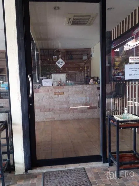 Shophouse for sale in Lam Luk Ka, Pathum Thani - Glass-door entrance to the shophouse with tiled lobby and service counter.