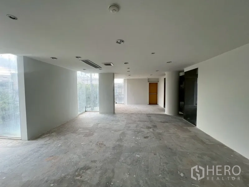 展厅 出租在Khlong Toei, Bangkok - 采光充足的转角空间，落地窗与白墙，适合展示或办公室。