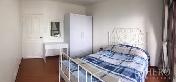 คอนโด ให้เช่าหรือขายในDin Daeng, Bangkok - ห้องนอนสว่าง เตียงเหล็กสีขาว ตู้เสื้อผ้า และโต๊ะเครื่องแป้ง บนพื้นไม้.