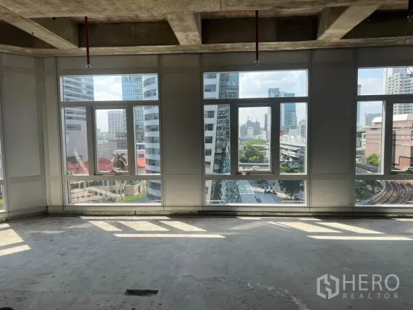 พื้นที่ขายปลีก ให้เช่าในBang Rak, Bangkok - วิวเมืองสีลอมและรางรถไฟฟ้าจากหน้าต่างบานกว้างของพื้นที่ค้าปลีกชั้นสูง.