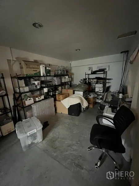 零售空间 出租在Watthana, Bangkok - 储物间配金属置物架、纸箱与办公椅，位于商铺后勤区。