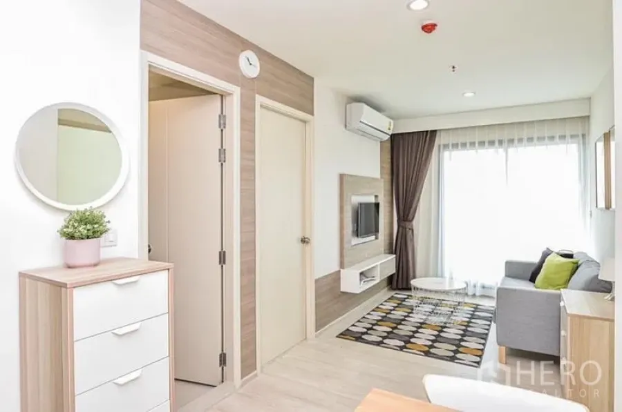 คอนโด ให้เช่าในDin Daeng, Bangkok - มุมมองห้องนั่งเล่นไปยังระเบียง มีเครื่องปรับอากาศและผนังทีวีบิวท์อิน