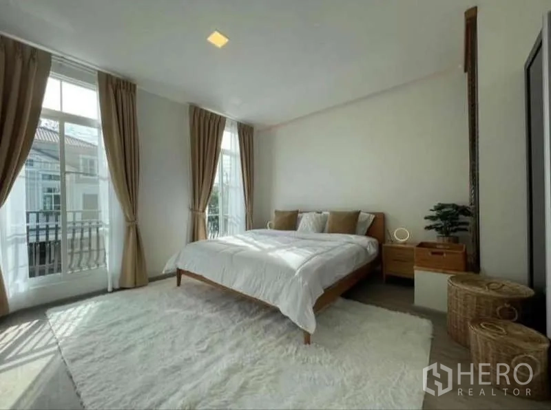 ทาวน์เฮาส์ ให้เช่าในPrawet, Bangkok - ห้องนอนมาสเตอร์พร้อมหน้าต่างสูง ผ้าม่าน และพรมสีอ่อน