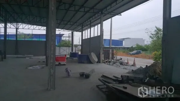 货栈 出租在Khlong Sam Wa, Bangkok - 仓库开口临路，部分墙体与施工材料可见