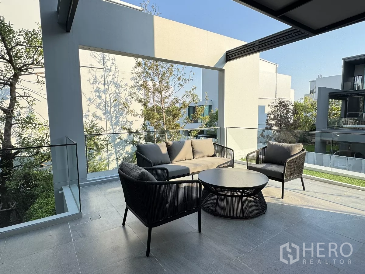 Detached House for rent in Saphan Sung, Bangkok - Large covered terrace with outdoor sofa set, glass balustrade and community views.