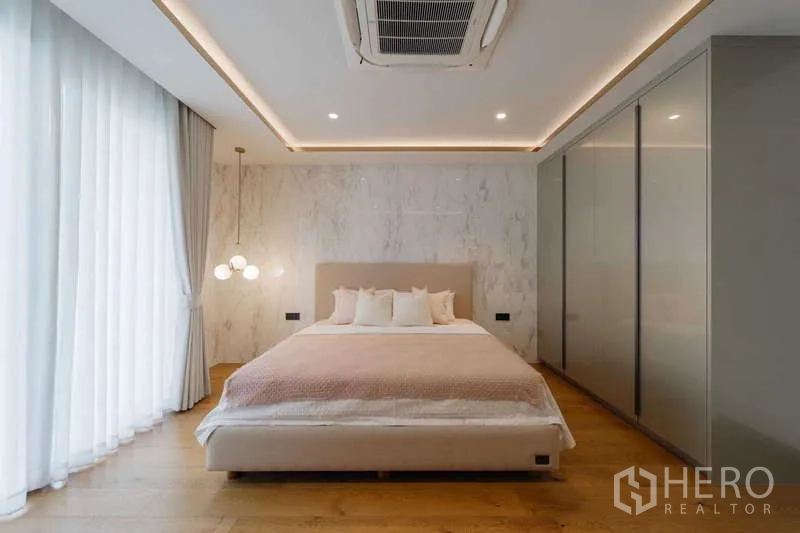 ทาวน์เฮาส์ ให้เช่าหรือขายในWatthana, Bangkok - ห้องมาสเตอร์พร้อมเตียงคิง โคมไฟแขวน และผ้าม่านโปร่ง