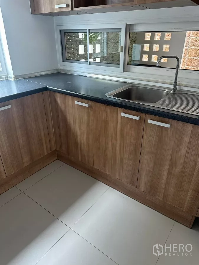 Detached House for rent or sale in Bang Phli, Samut Prakan - Second angle of the kitchen showing sink, upper cabinets and sliding window.