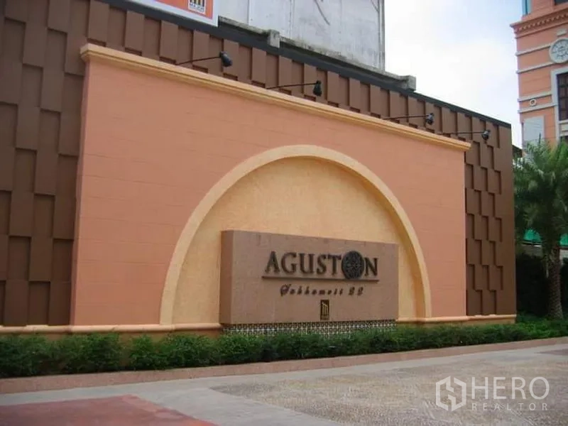 คอนโด ขายในKhlong Toei, Bangkok - ป้ายทางเข้าโครงการคอนโด Aguston พร้อมผนังโค้งและจัดสวน