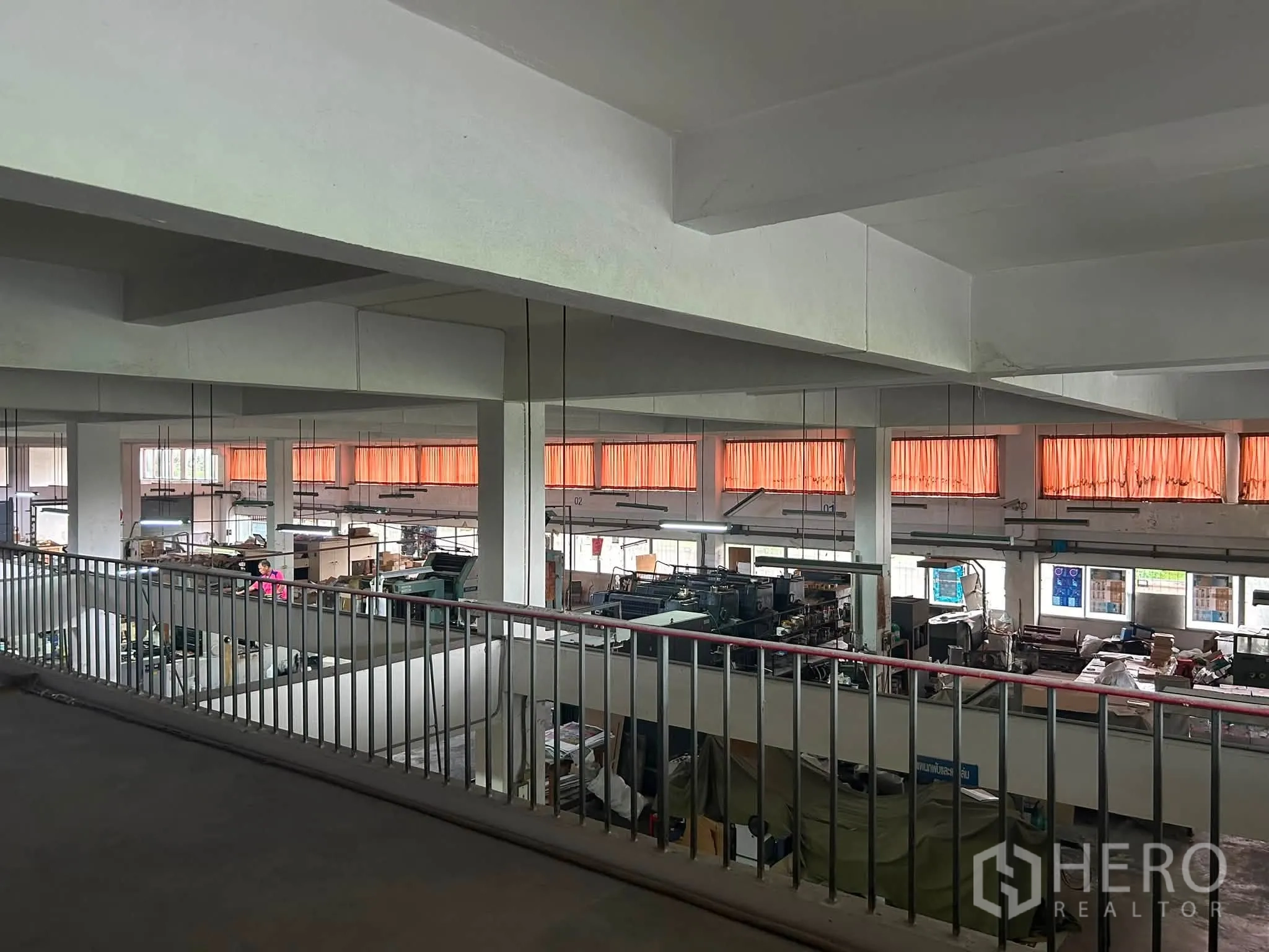 โกดัง for rent in Phra Khanong, Bangkok - ชั้นลอยมองลงสู่พื้นที่โกดังขนาดใหญ่พร้อมเสา หน้าต่าง และไฟแขวน