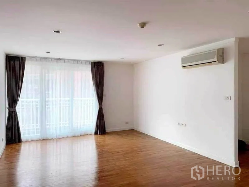 คอนโด ให้เช่าในSathon, Bangkok - ห้องนั่งเล่นกว้าง พื้นไม้ ผ้าม่านโปร่ง และประตูกระจกเลื่อนออกสู่ระเบียง พร้อมแอร์ผนัง