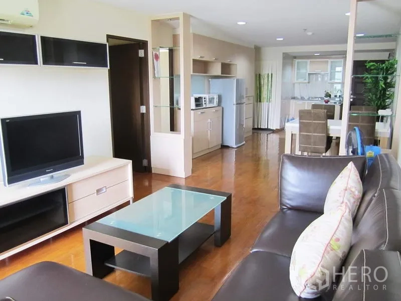 คอนโด ให้เช่าในBang Rak, Bangkok - มุมนั่งเล่นพร้อมโซฟาหนัง โต๊ะกลางกระจก ชุดทีวี มองเชื่อมถึงครัวและพื้นที่ทานอาหาร