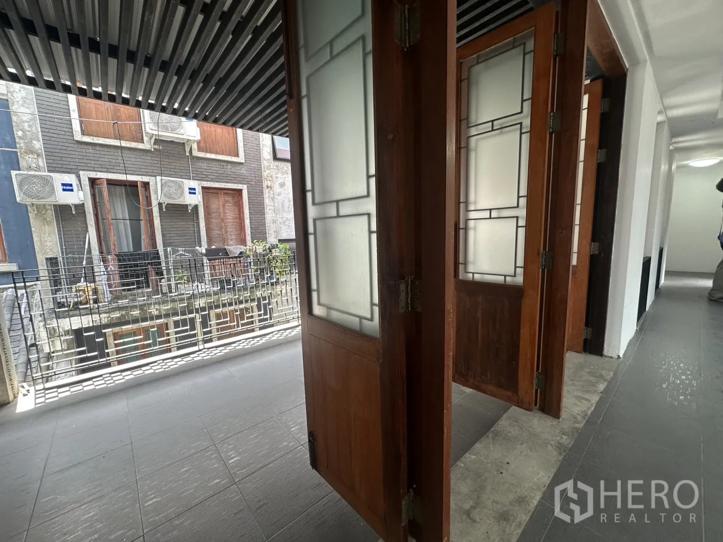 สำนักงานที่บ้าน ให้เช่าในPathum Wan, Bangkok - ภาพระยะใกล้ของประตูไม้บานพับเปิดสู่ระเบียง เห็นคอมเพรสเซอร์แอร์