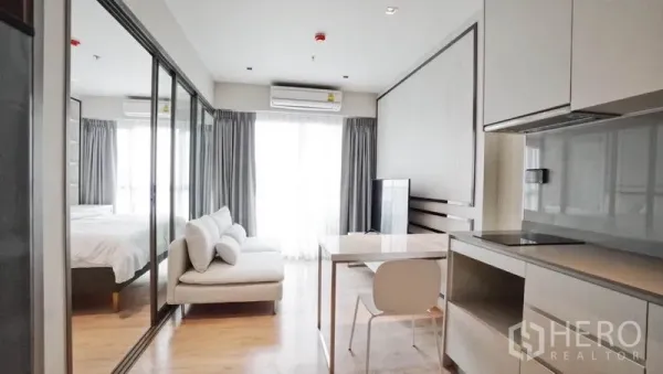 คอนโด ขายในKhlong Toei, Bangkok - ห้องนั่งเล่นสว่างแบบเปิดโล่ง พร้อมครัวขนาดกะทัดรัด โต๊ะทานอาหาร และประตูกระจกกั้นห้องนอน