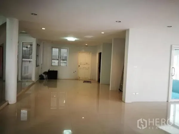 独立式住宅 出租在Phra Khanong, Bangkok - 宽敞的开放式客厅，亮面地砖、白墙与嵌灯。