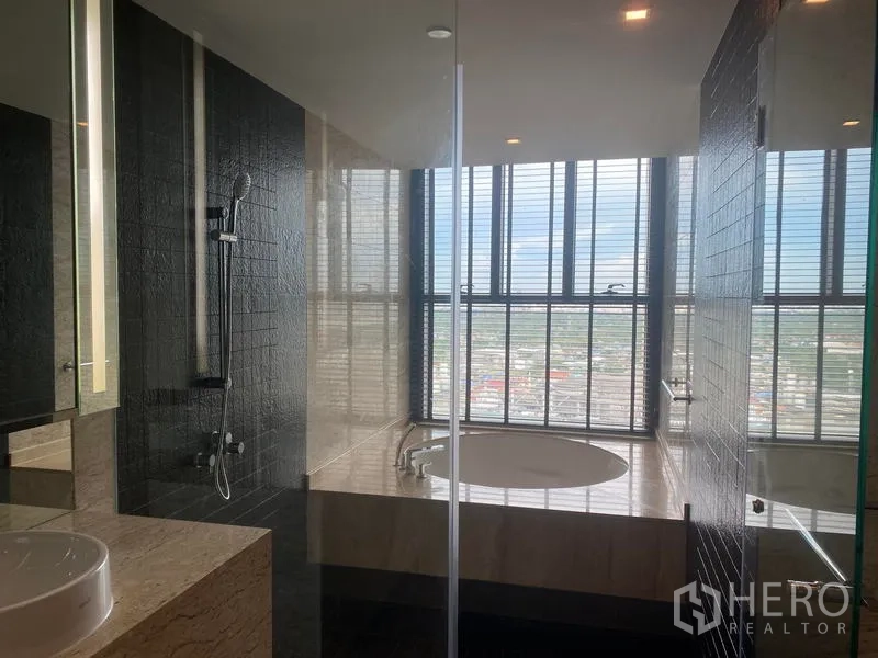 Condominium for rent - Spa-style bathroom with walk-in shower and round soaking tub beside large windows with city views.