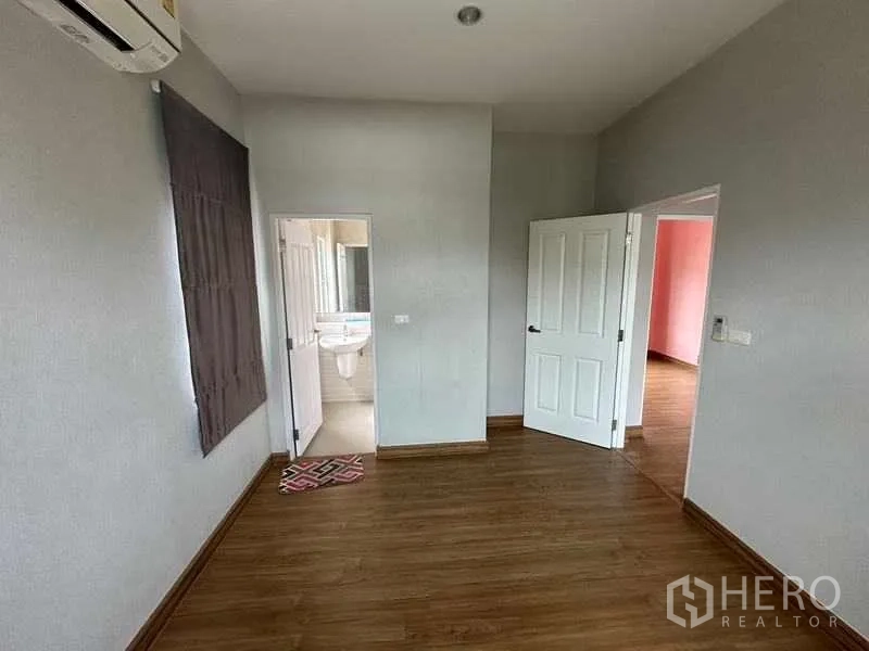 Detached House for sale in Bang Khen, Bangkok - Upstairs bedroom with air-conditioning and door to a private bathroom.