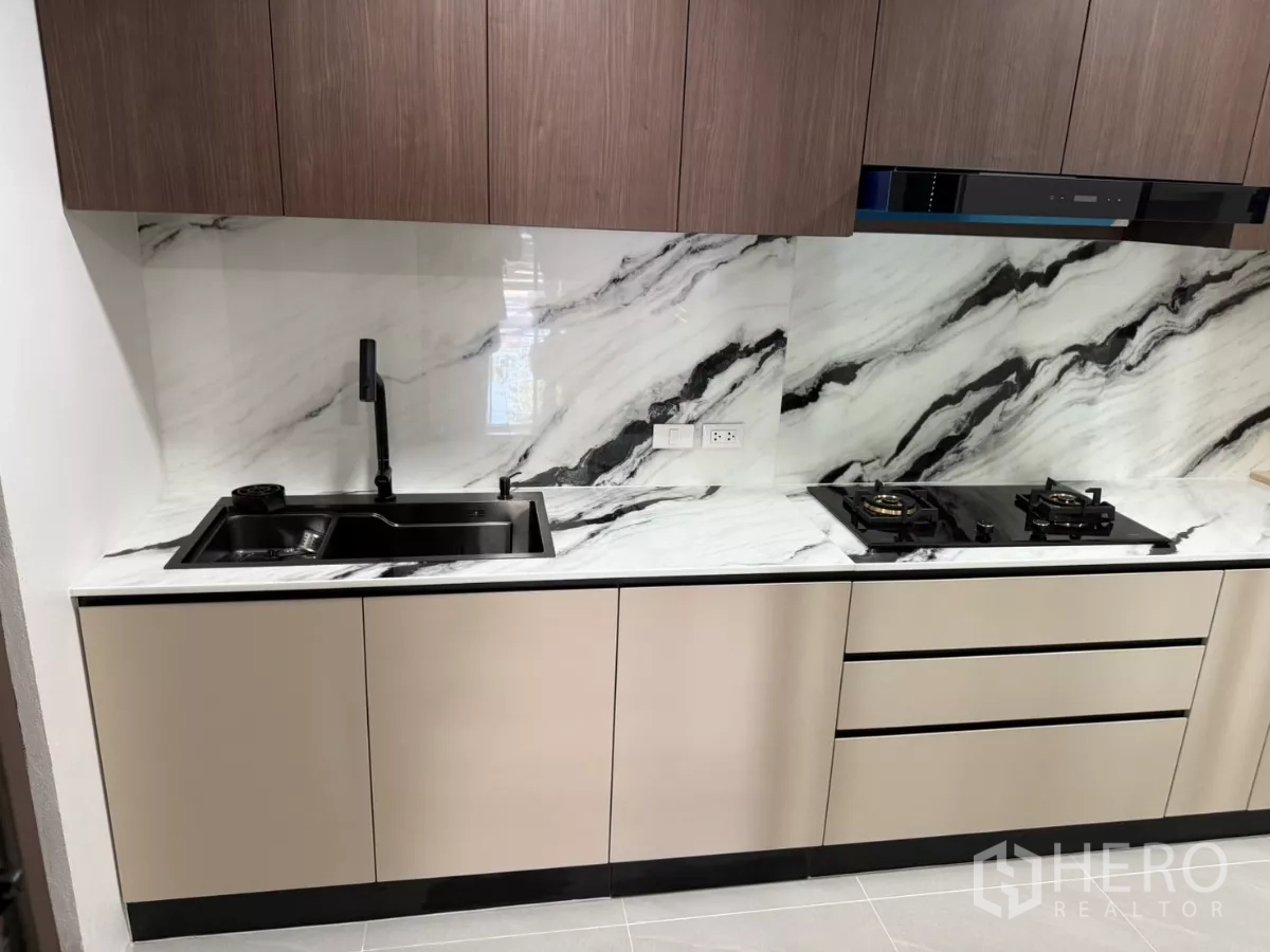 Townhouse for rent or sale in Bang Phli, Samut Prakan - Kitchen counter with double sink, gas cooktop and glossy stone surfaces.